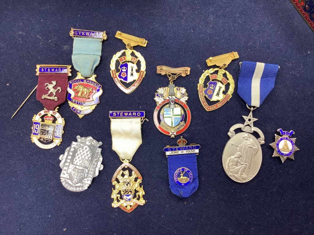 A collection of assorted enamel badges and nursing badges